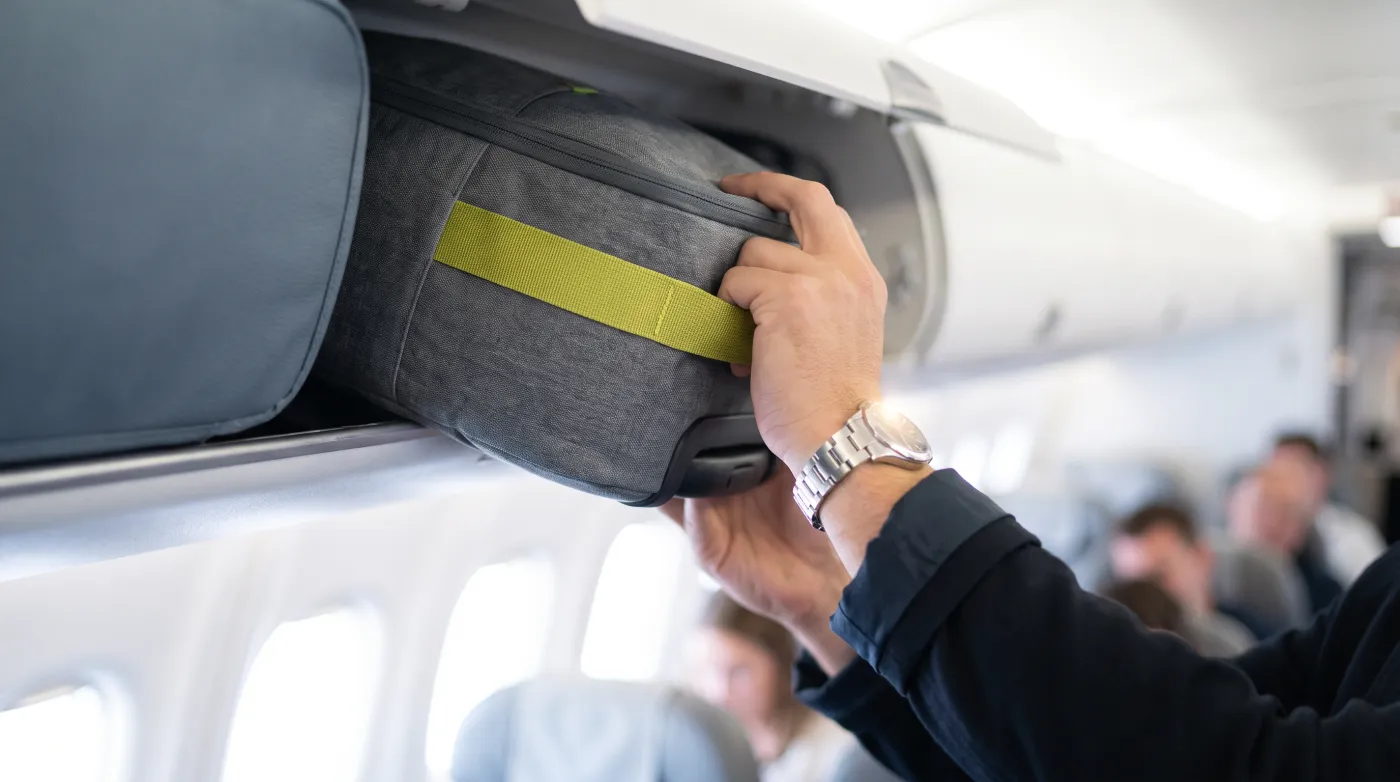 Viajante guardando a bagagem de mão no avião
